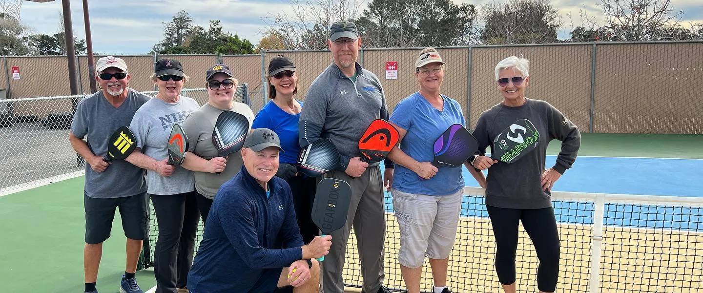 Pickleball players posing on the court.